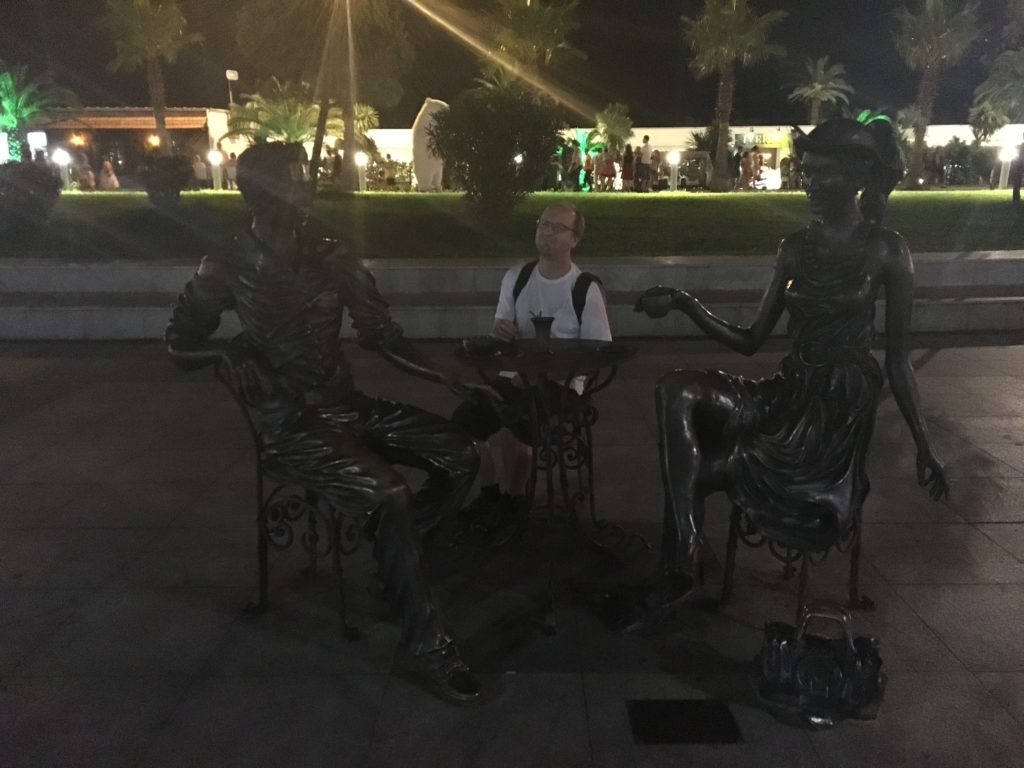 Mann an Tisch mit Statuen